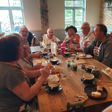 A group of people seated around a table enjoying food and drinks in a lively setting.